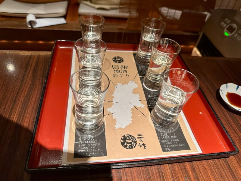 だいだらぼっちの信州地酒めぐり ６種類呑みくらべでグラスがお盆に並べてあるところ