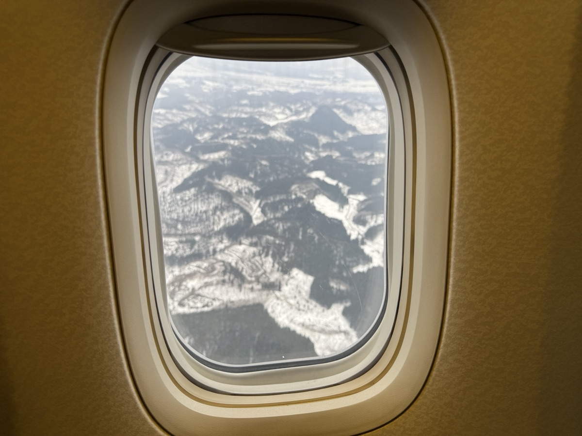 飛行機の窓から見えた秋田の雪が降る山