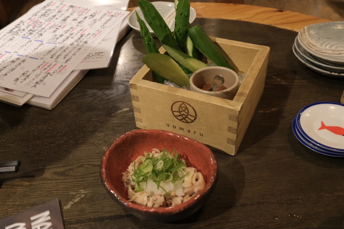 （奥）お通しのもろきゅう （手前）ひね鶏ねぎポン酢