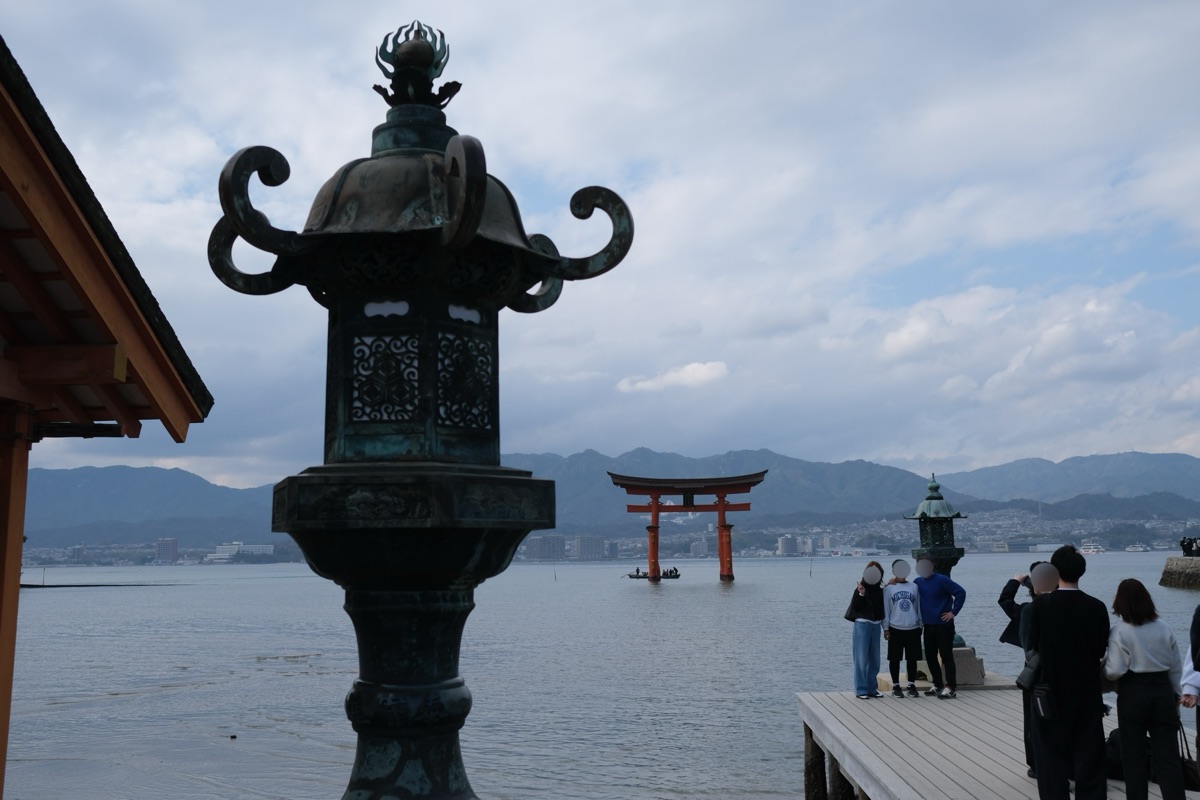 嚴島神社の大鳥居と燈篭、写真撮影をする人々